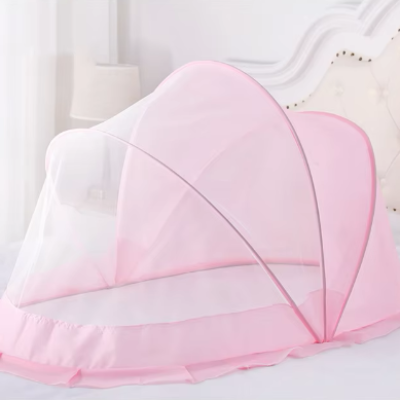 Une moustiquaire pour lit bébé délicatement rosée est posée sur le lit pour offrir un cocon sécurisé