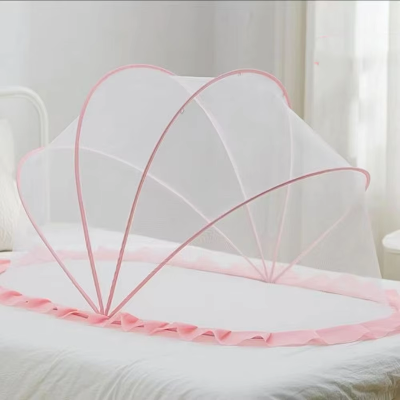 Une moustiquaire pour lit bébé en forme de dôme pensée pour les bébés et teintée de rose doux repose élégamment sur le lit.