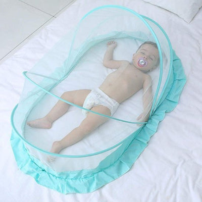 Une moustiquaire pour lit bebe en forme de petit dôme, est posée sur un lit et protège un bébé endormi à l’intérieur.