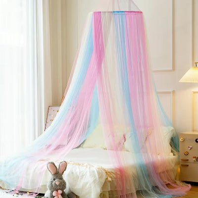 Une moustiquaire pour lit aux couleurs pastel de l'arc-en-ciel suspendue et flottant autour du lit qui transforme la chambre en un cocon doux et magique.