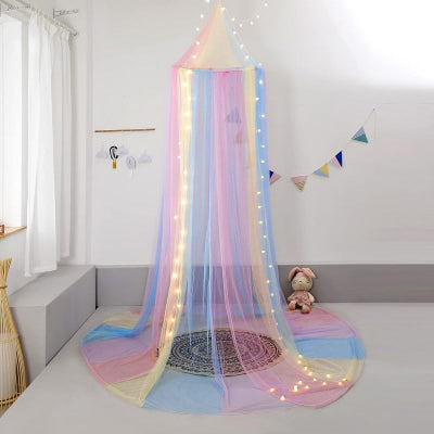 Une moustiquaire pour lit flottante aux nuances pastel suspendue au-dessus du coin jeu qui apporte douceur et magie.