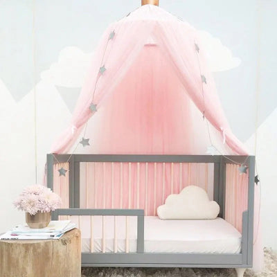 Une moustiquaire pour lit rose accrochée au-dessus du lit de bébé