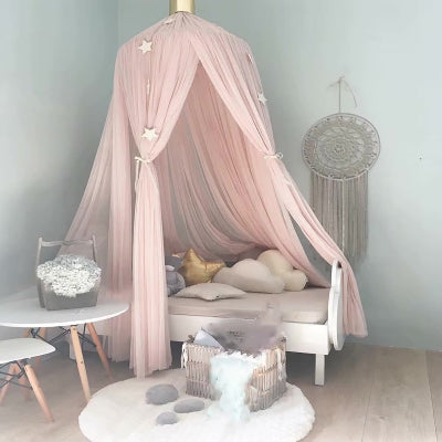 Une moustiquaire pour lit rose qui se suspend au-dessus du lit de bébé