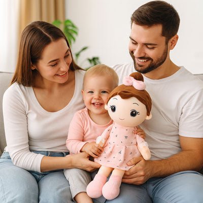 parents assissent sur le canapé, leur enfant est sur les genoux, poupée de chiffon dans les mains