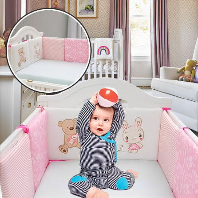 Le petit garçon joue avec une balle dans son lit, bien entouré par son tour de lit bébé