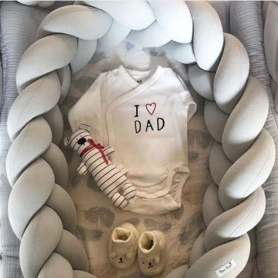 Les petits vêtements attendent dans le reducteur de lit pour bebe SweetSnug™  gris, prêt à accueillir bébé dans son lit