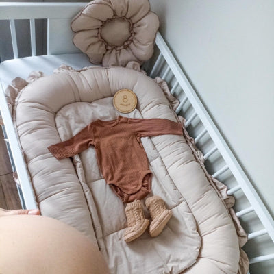  Le reducteur de lit HaveSaf™ couleur beige déposé dans le lit de bébé.