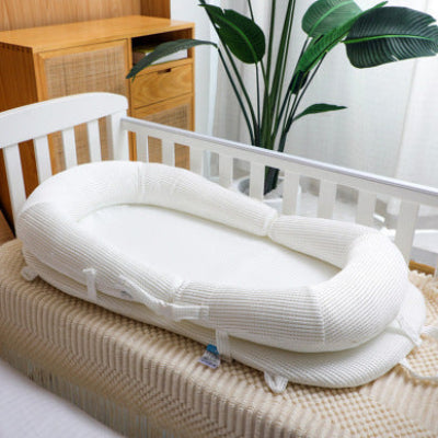 reducteur de lit bebe WeedgePood™ blanc, déposé sur le lit