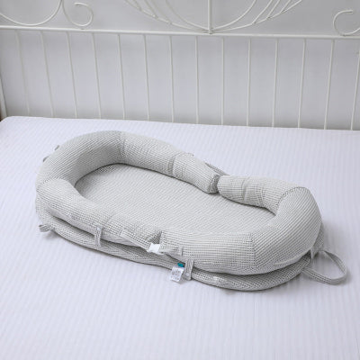 reducteur de lit bebe WeedgePood™ gris, déposé sur le lit