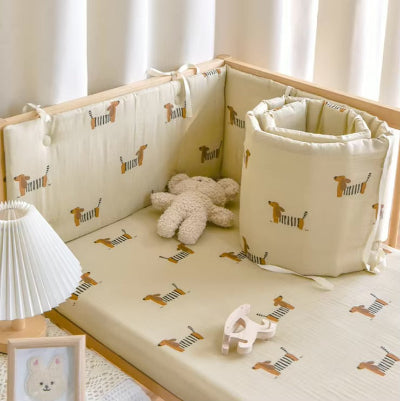 Tour de lit bebe beige décoré de petits chiens est placé dans un lit bébé pour apporter confort et protection