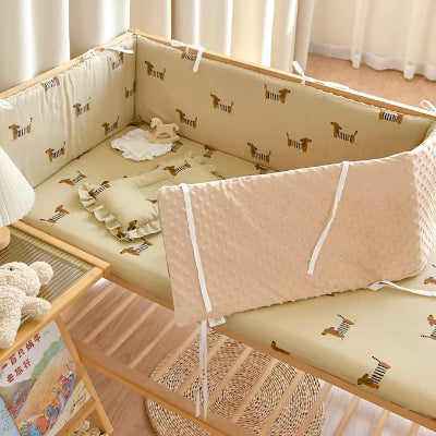 Tour de lit bebe douillet beige décoré de petits chiens protégé le bébé des barreaux tout en rendant son lit plus cosy