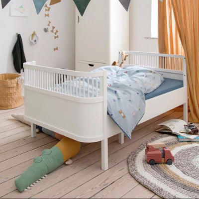 Le tour de lit colore en forme de crocodile est placé sous le lit de l'enfant