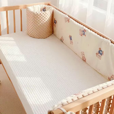 Tour de lit matelasse beige à motif d'ours enveloppe le lit créant un cocon confortable et protecteur