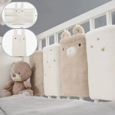 Un tour de lit modulable compose de coussinets doux et moelleux dont un en forme d'ourson enveloppe les barreaux du lit pour offrir confort et protection à bébé.