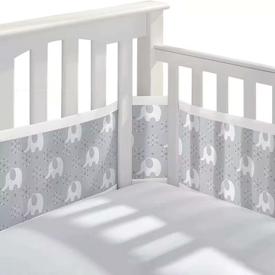 Un tour de lit respirant gris à motifs d’éléphants entoure le lit.
