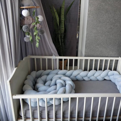 tour de lit tresse bleu pastel est enroulé tout autour du lit bébé