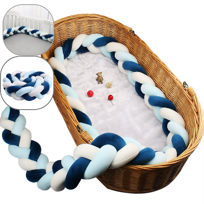 Un tour de lit tresse aux tons bleu, blanc et turquoise est installée tout autour d'un couffin en osier créant un espace doux et sécurisé pour le bébé.