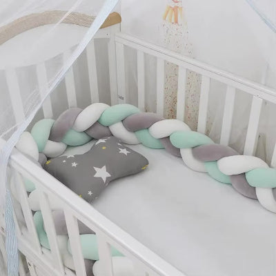Tresse tour de lit gris blanc et vert dans le lit bébé blanc apportant douceur et protection