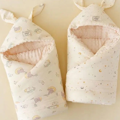 la turbulette à motif d’éléphants et celle parsemée de lunes et d’étoiles attendent l'enfant pour de doux rêves.